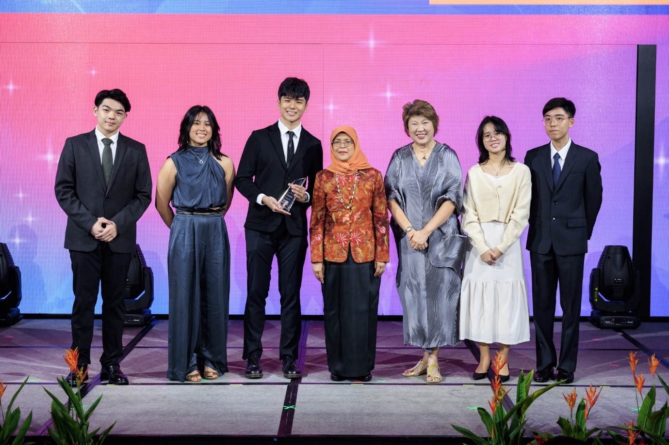 Benoit Chia (holding trophy) and his team receiving an award from Singapore President Halimah Yacob.