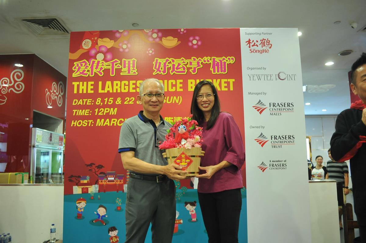 Stephanie Ho, General Manager, Retail Properties, presents a symbolic rice bucket to Shan You Wellness Centre.