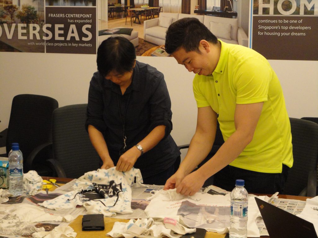 The Frasers Centrepoint Commercial team in the midst of cutting up their old shirts.