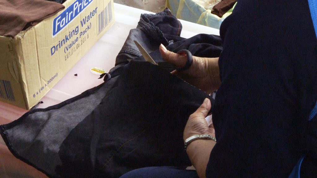Some of the ladies sewing and cutting cloth to use as rags for cleaning.